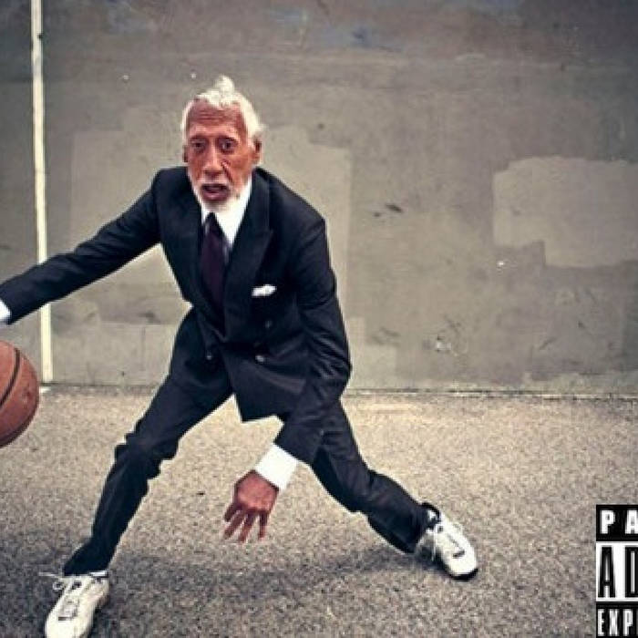 a man in a suit dribbling a basketball