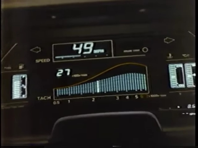 An 80s car dashboard in black and with white outlines and glowing greenish-white numbers and visualisations