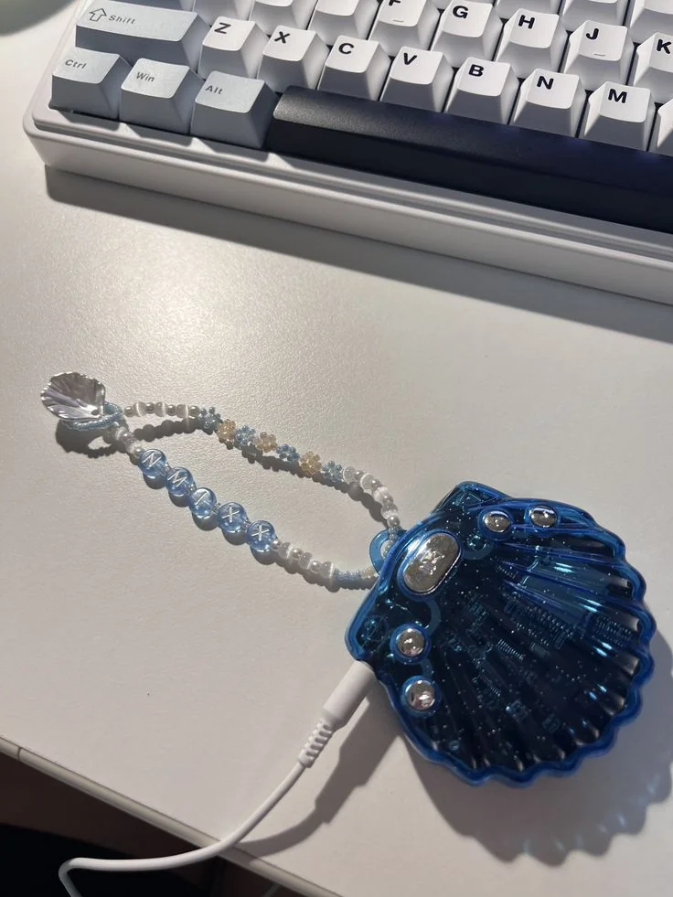 a deep blue transparent seashell shaped mp3 player with a charm wristband