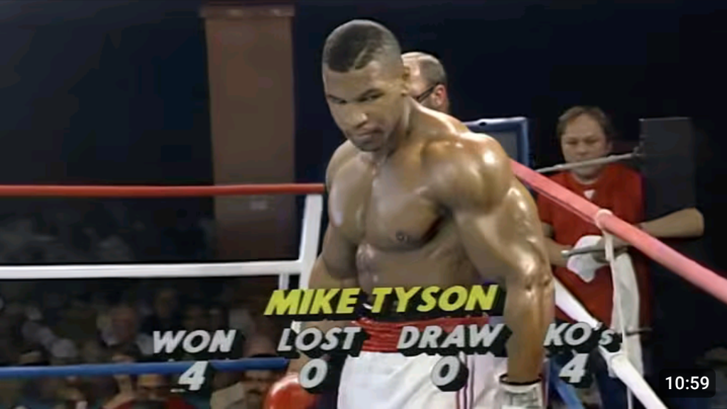 Mike Tyson with his record at the time (undefeated in 4 fights, all knockouts)